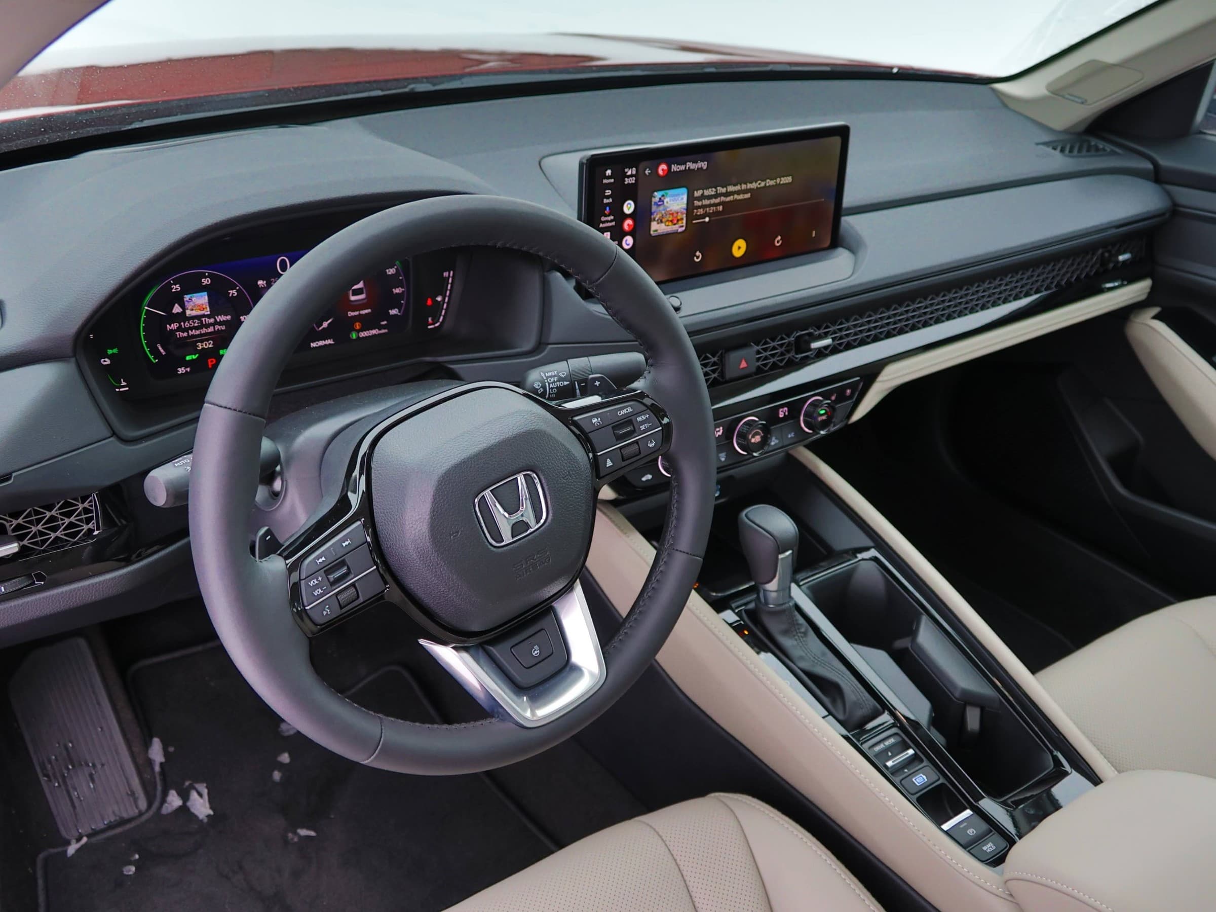 Honda Accord Hybrid dashboard with a digital gauge cluster, a wide center touchscreen, a honeycomb-pattern vent strip and a beige-trimmed center console.