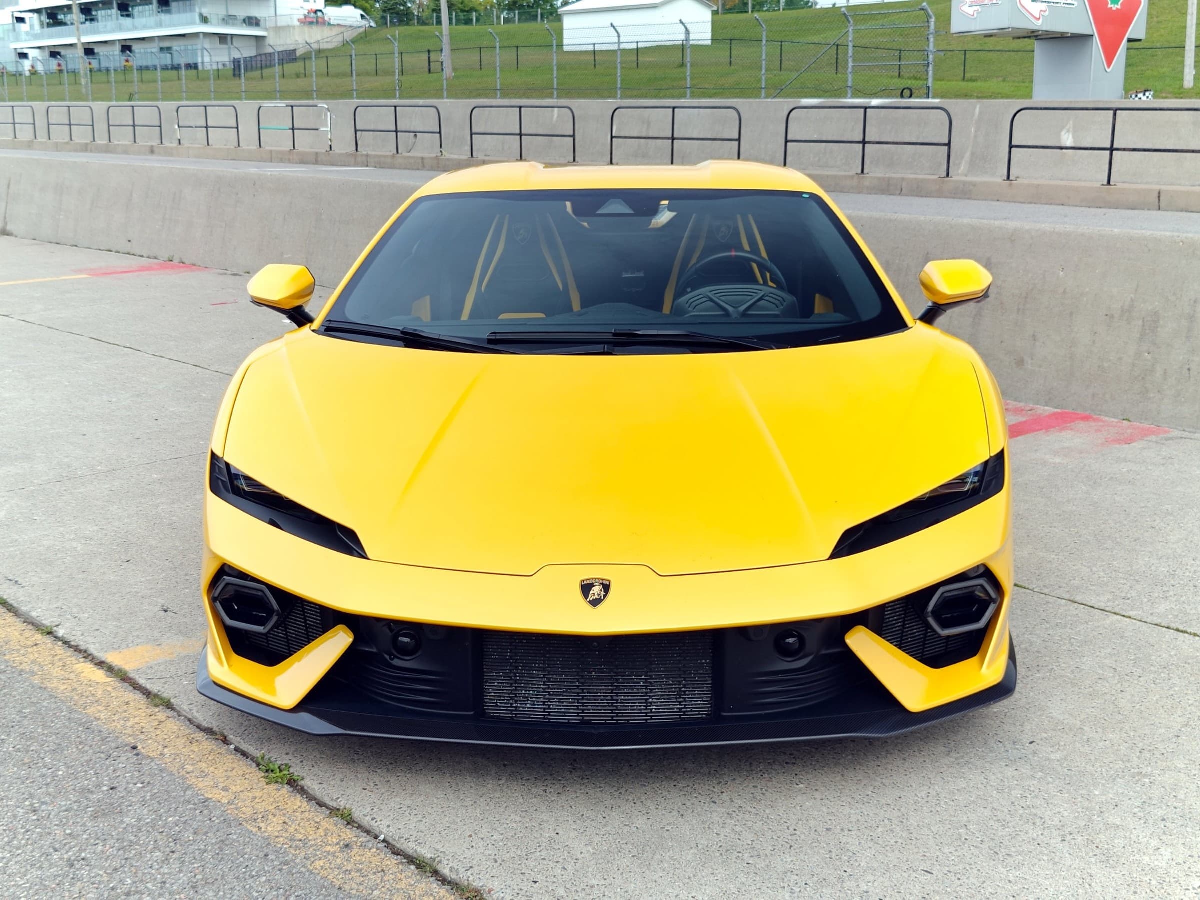 Head-on view of a yellow Lamborghini Temerario in the pit lane, with black and yellow seats visible through the windshield.