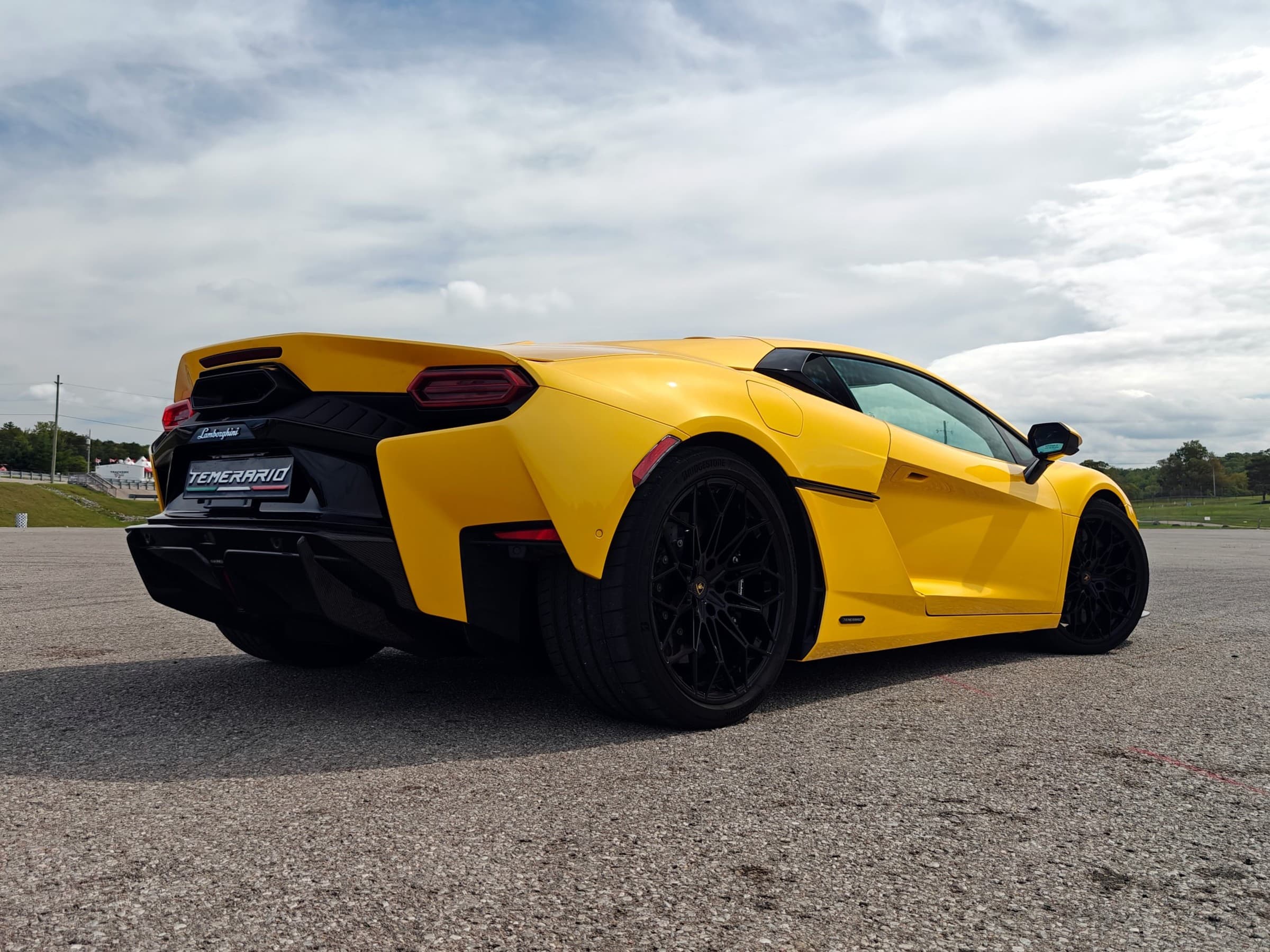 Low rear three-quarter view of a yellow Lamborghini Temerario showing its raised rear deck, hexagonal taillights and black diffuser.