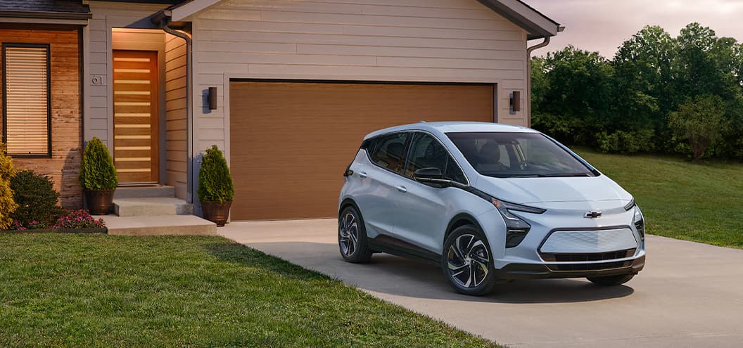 Light Blue Chevy Bolt parked outside in driveway