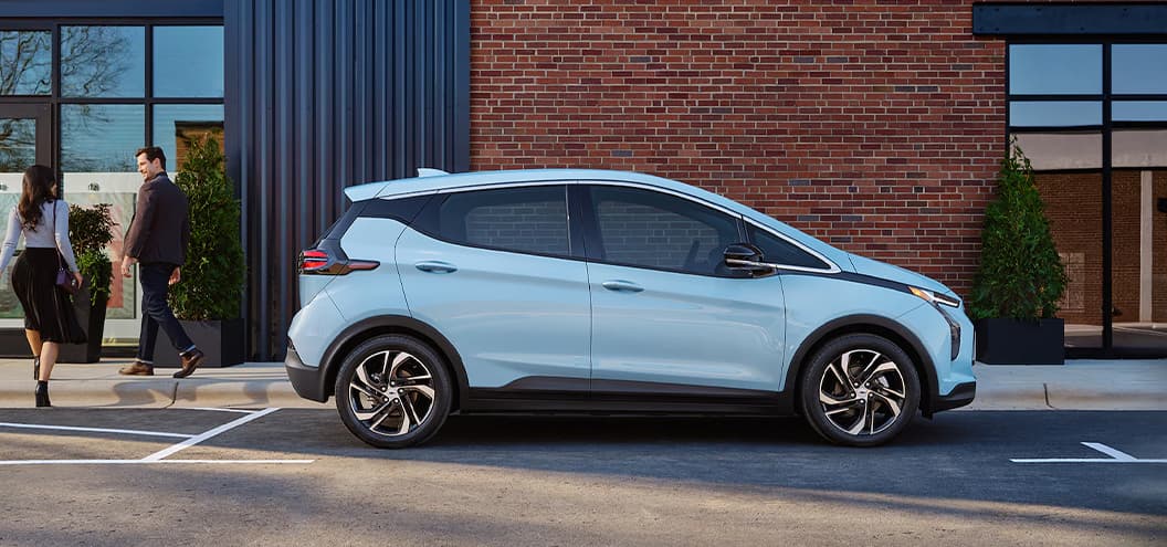 Chevy Bolt parked outside office building next to people