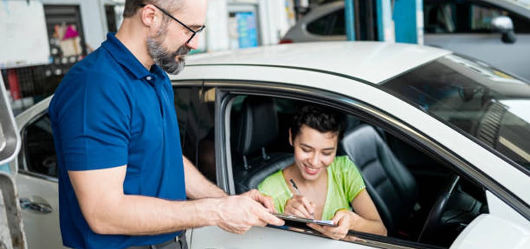 Woman signing paperwork while in car