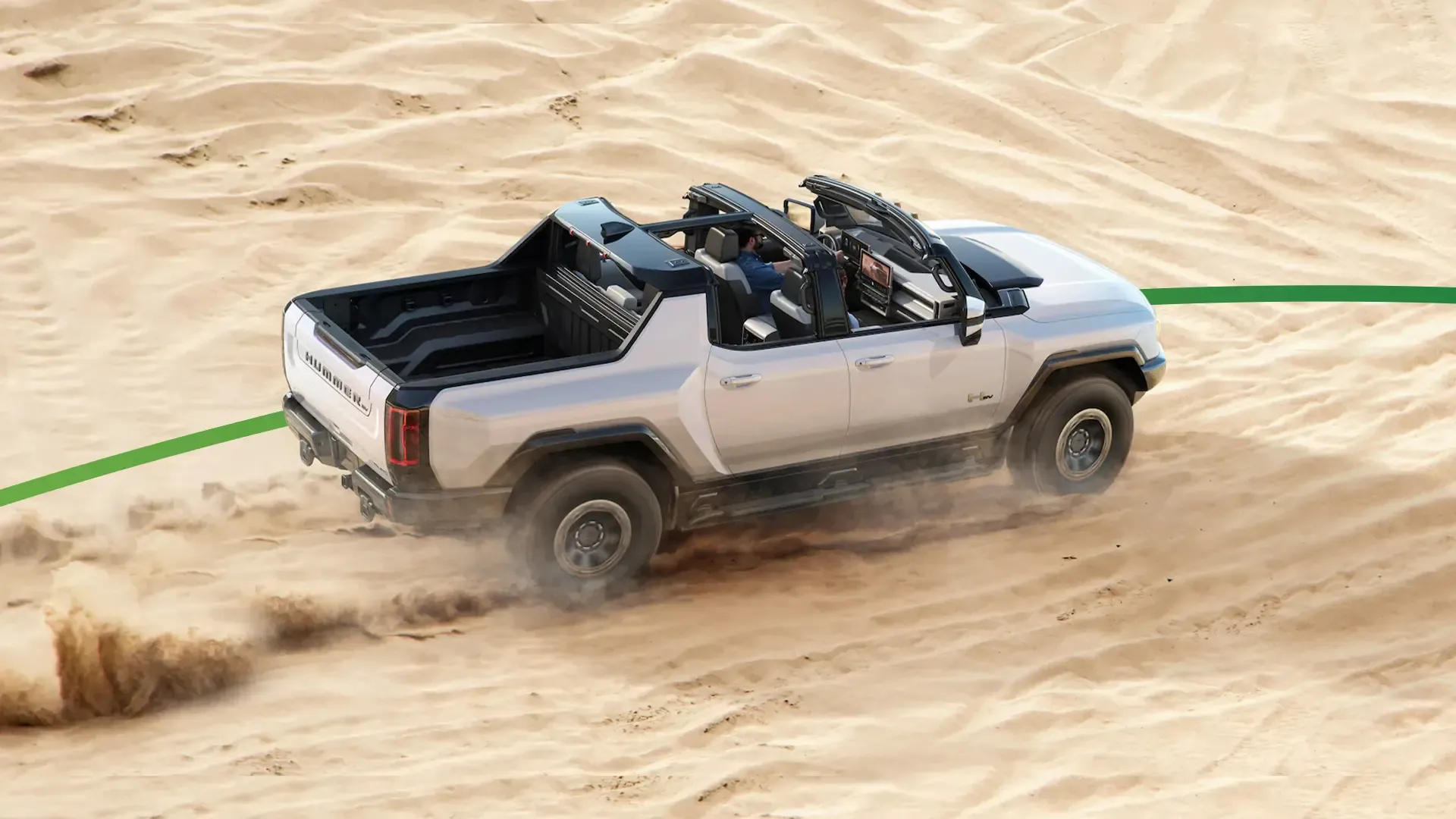 GMC Hummer EV driving through sand