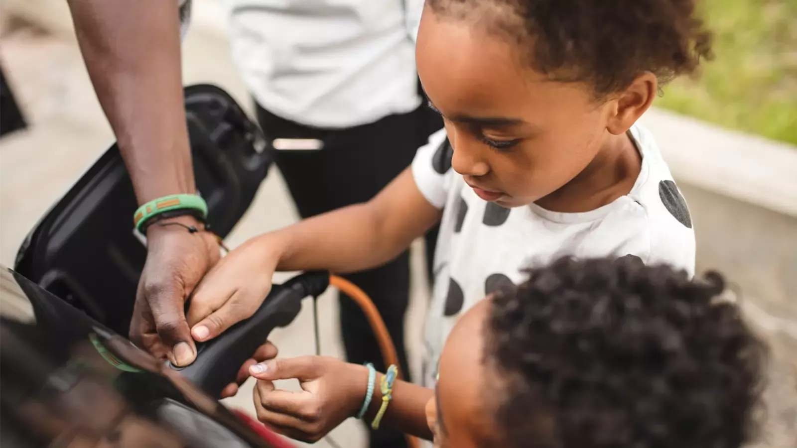 Child helping father charge car