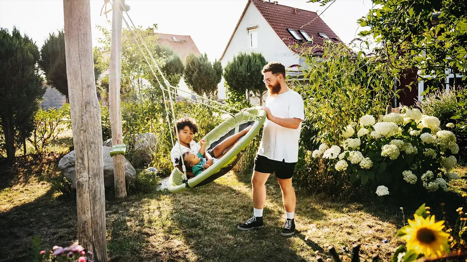 father pushing his son on a swing
