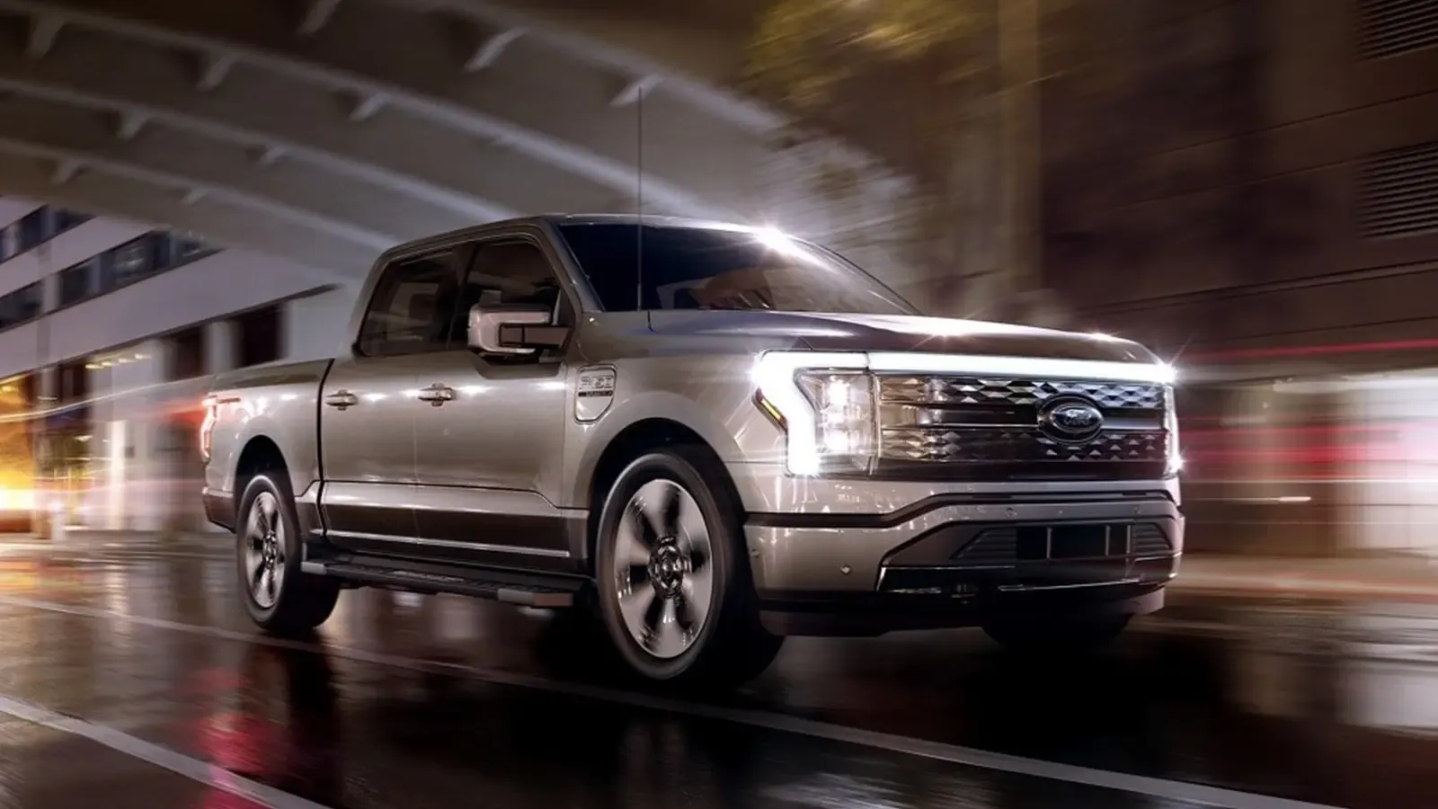 ford f-150 lightning driving underneath a cityscape