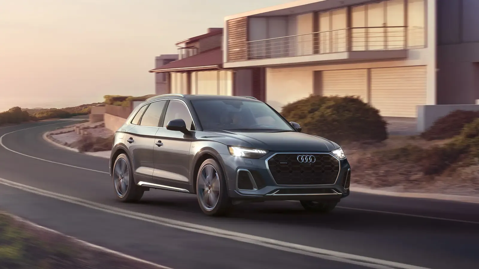 AUDI Q5 DRIVING DOWN THE ROAD IN TWILIGHT