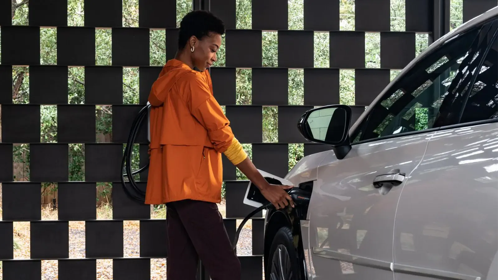 Woman charging her Lexus EV at home. 