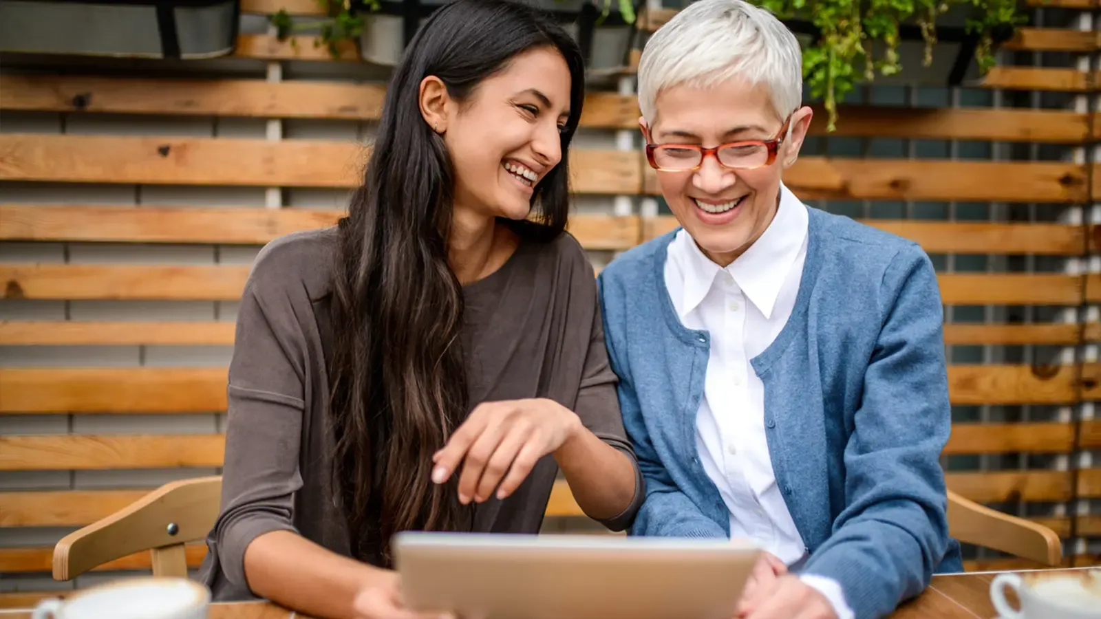 Two people using computer and smiling.