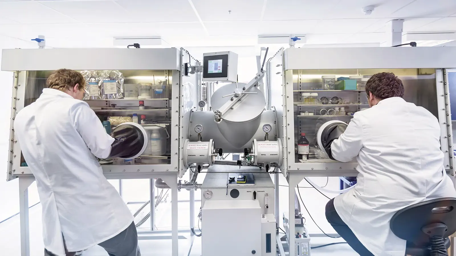 Scientists assembling lithium ion batteries in lab.