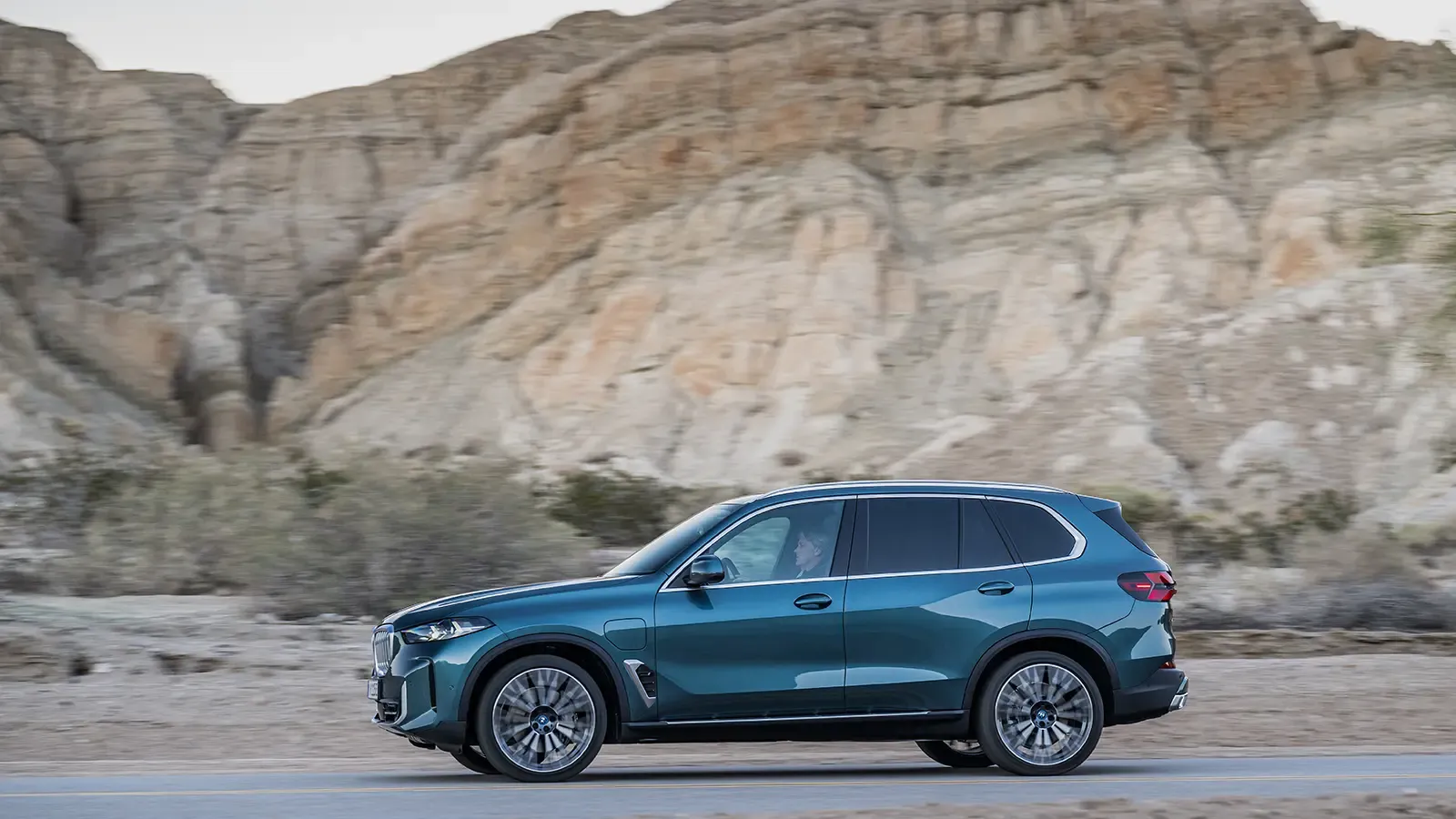 BMW X5 side view on road in desert