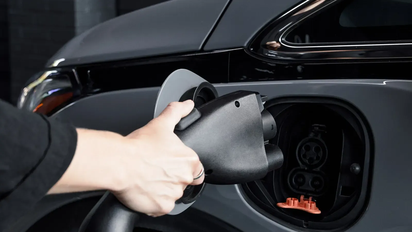 driver plugging in and charging their electric car