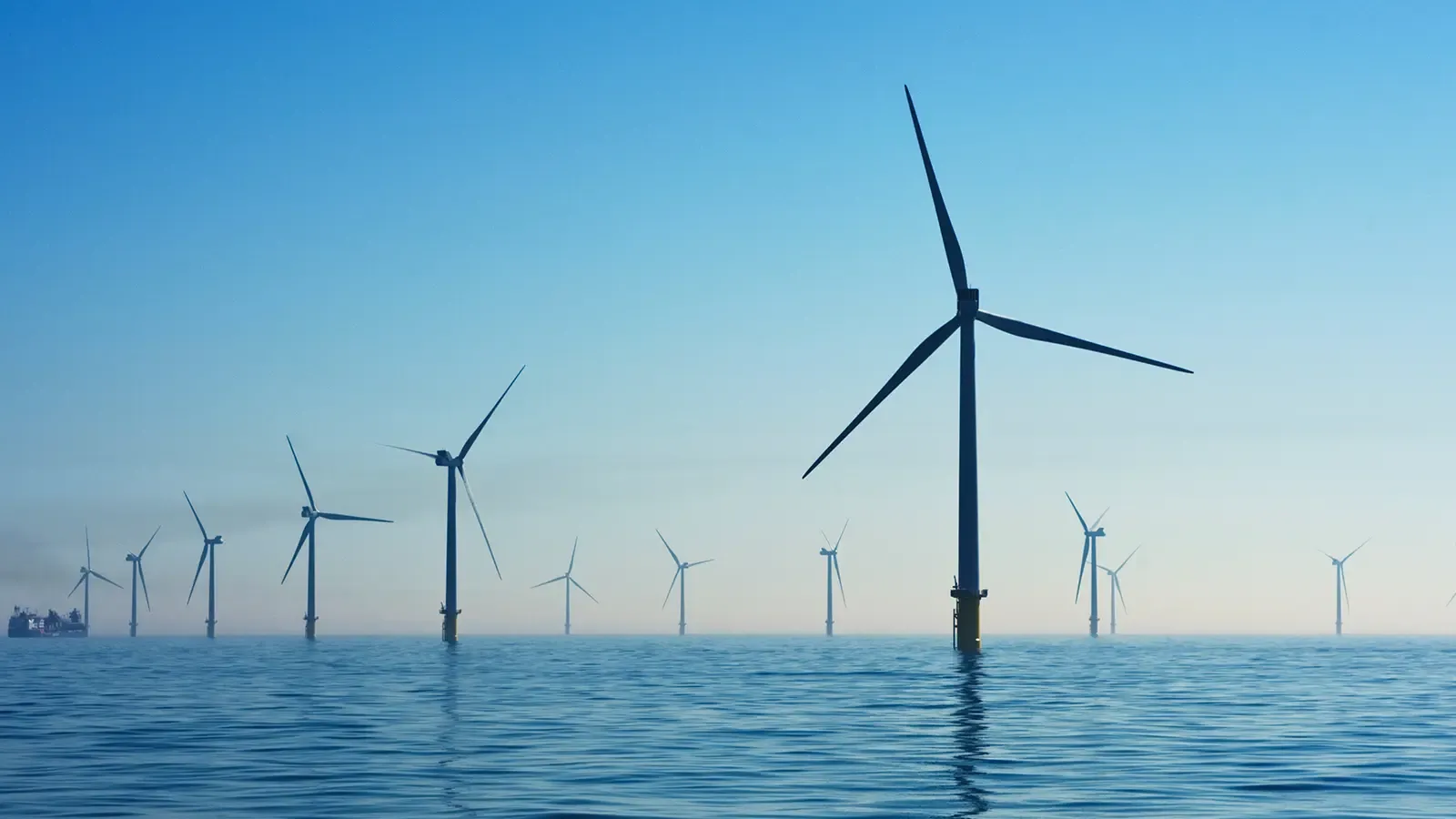 twelve wind turbines spinning in the ocean 