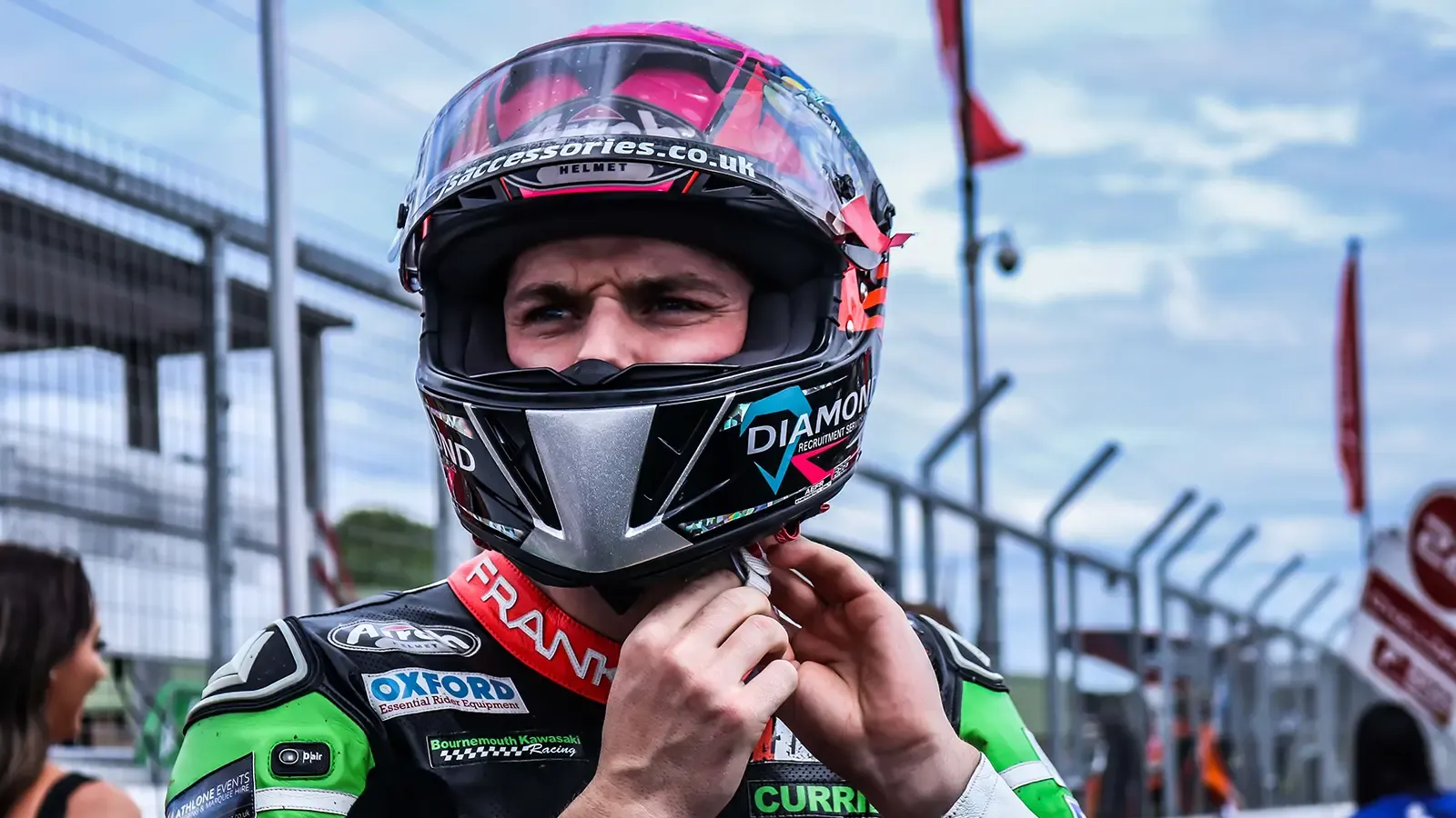 race car driver tightening helmet before race