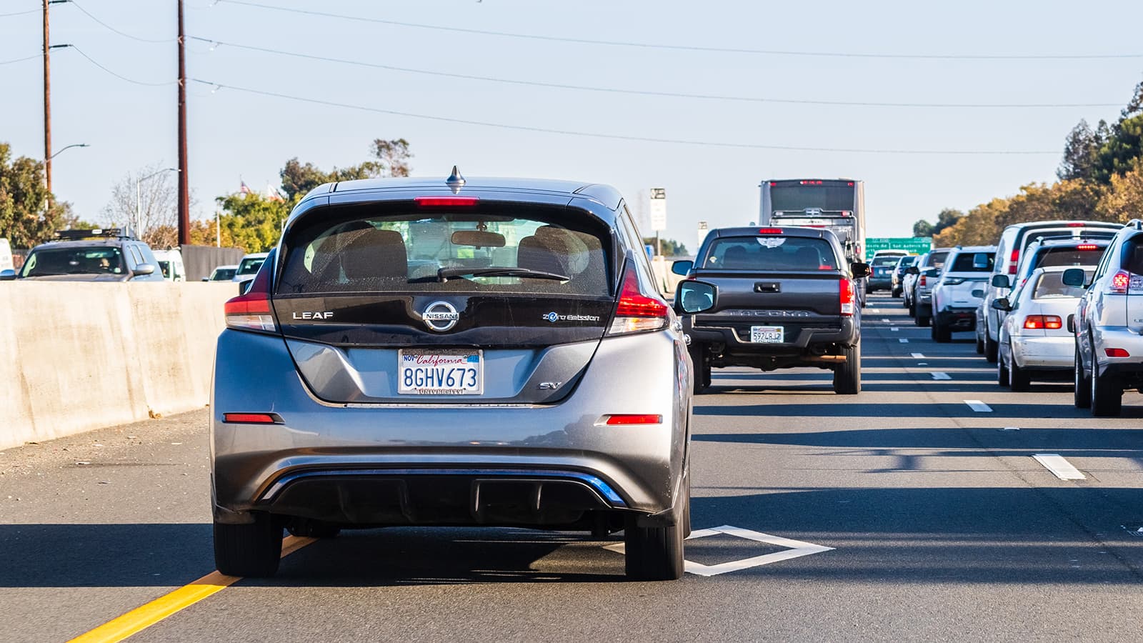 Nissan Leaf driving in a carpool lane on a busy interstate