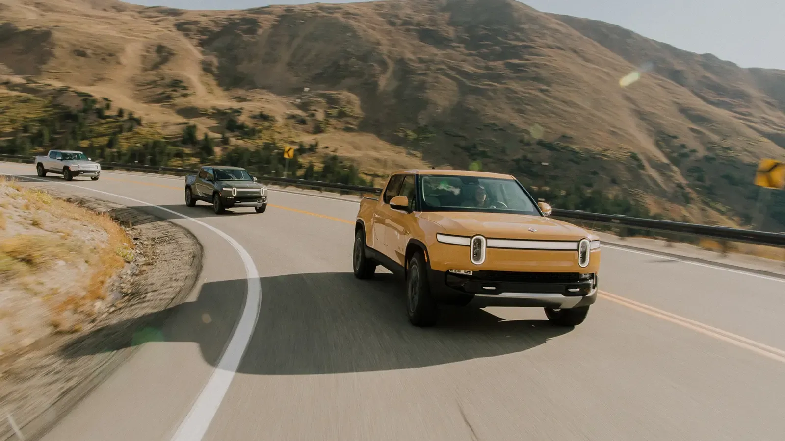 3 Rivian R1T pick up trucks on the road 