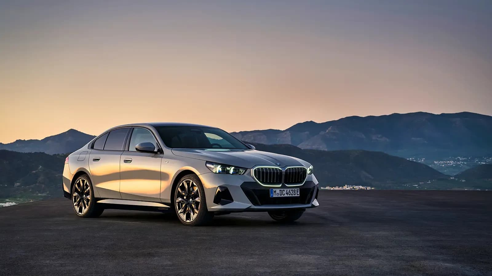 A 3/4 view of the BMW i5 EV and its lit-up kidney grille.