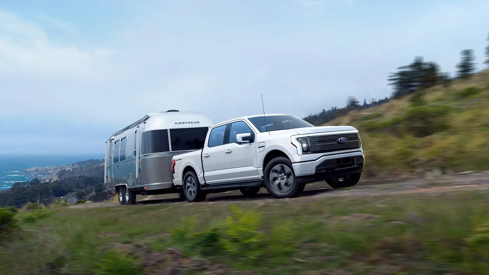 Ford F-150 Lightning towing an Airstream trailer along a mountain road