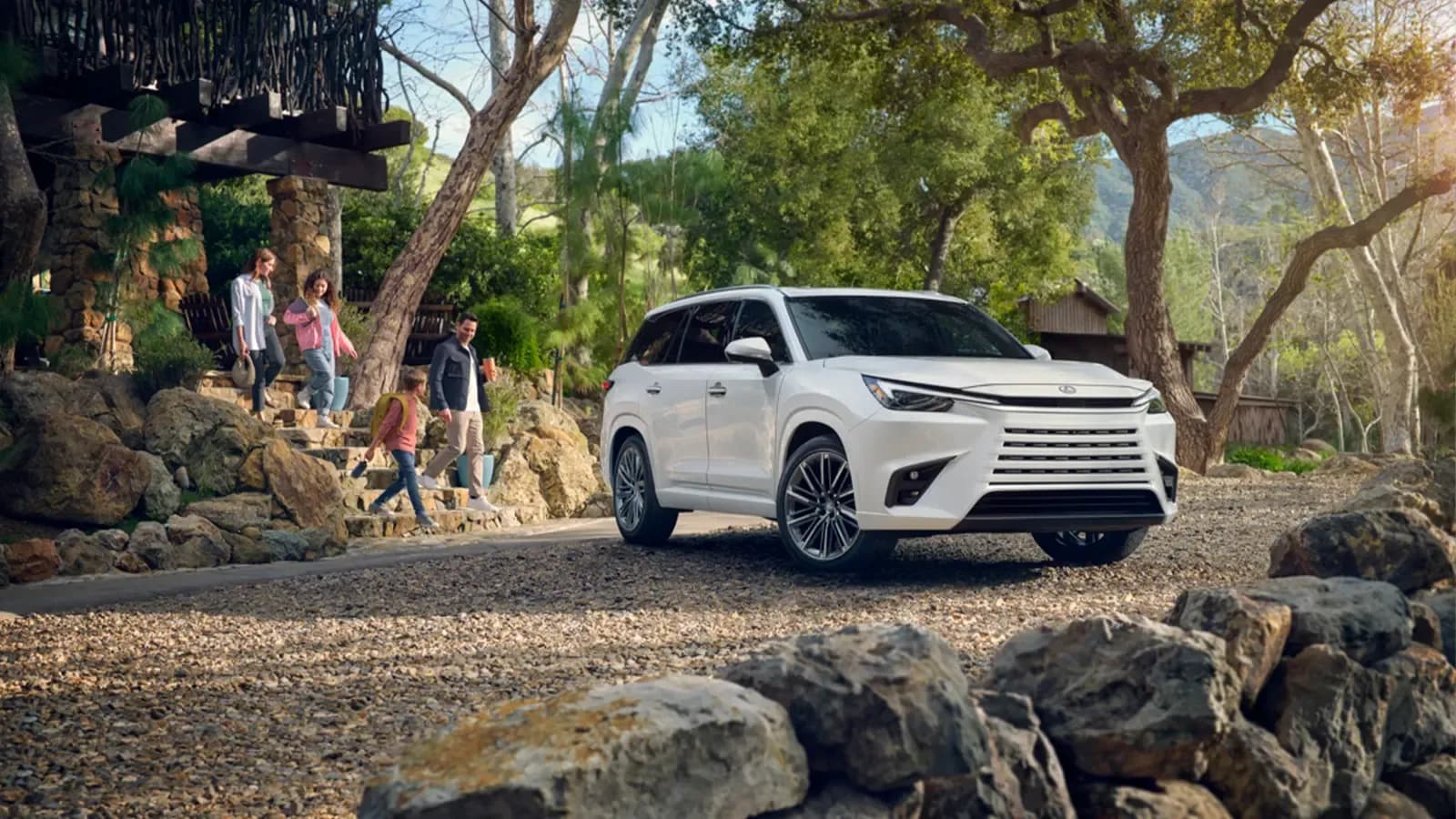 Young family at an outdoor park walking to their Lexus TX