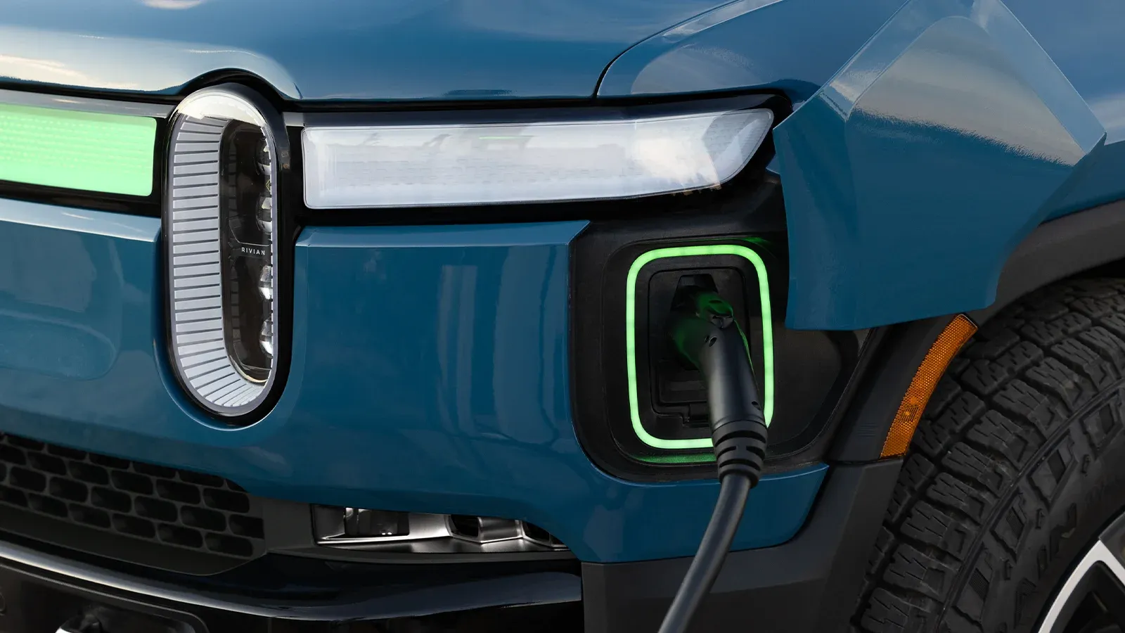 Close-up view of Rivian R1T charging port while plugged in and charging