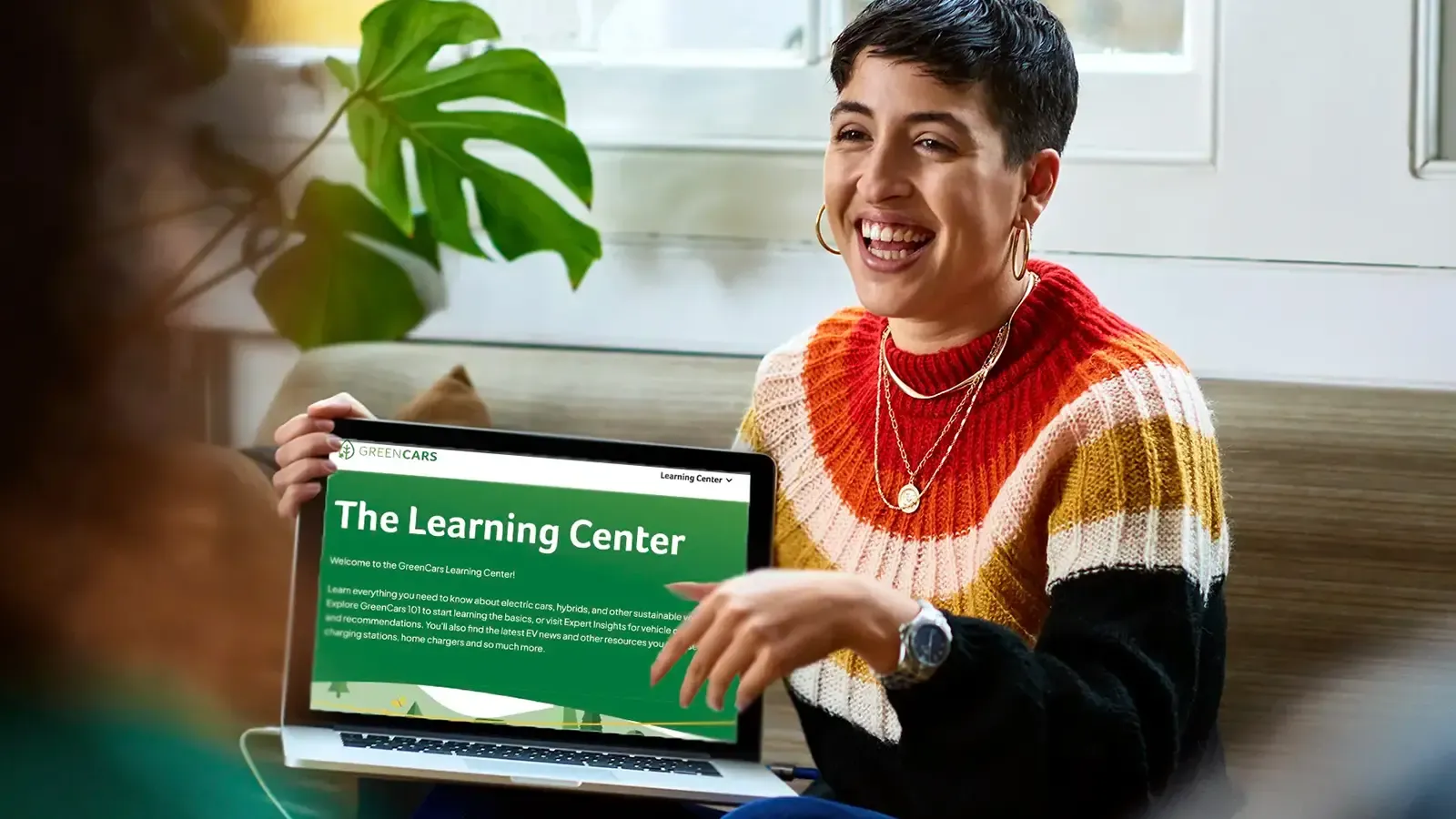 A woman with laptop displaying the Greencars learning center 