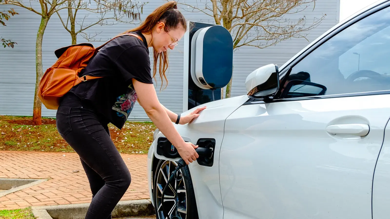 Woman charging car in public charging station 