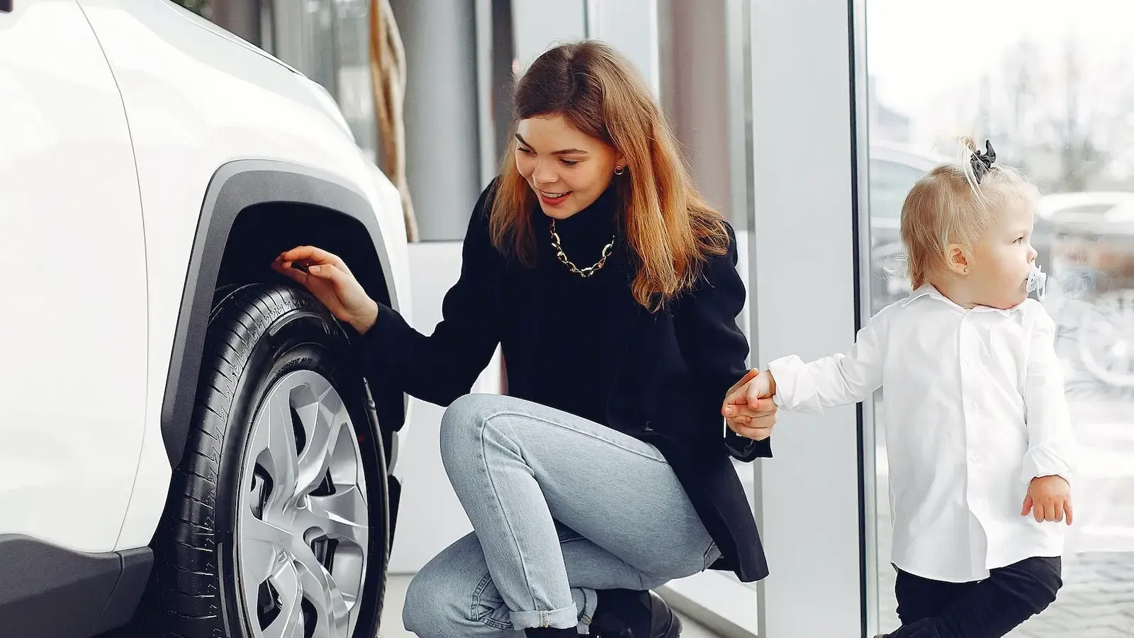 Woman buying a car with her toddler at a dealership