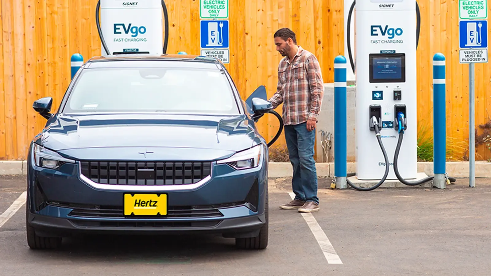 Man charging his car using the Hertz and EVgo charger