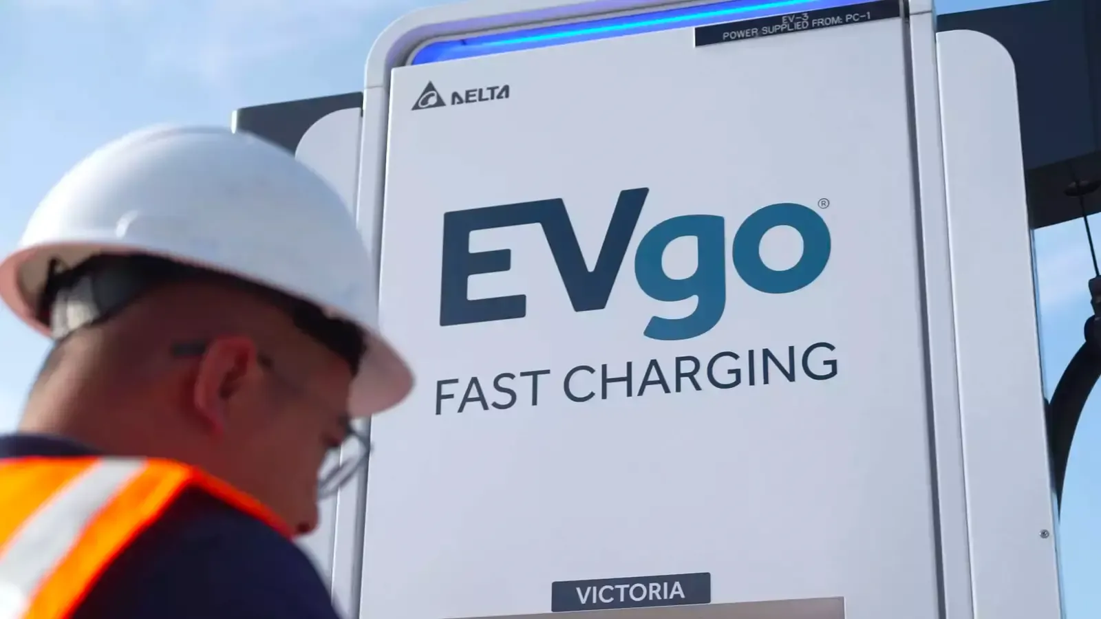 Construction worker standing by EVgo charging station