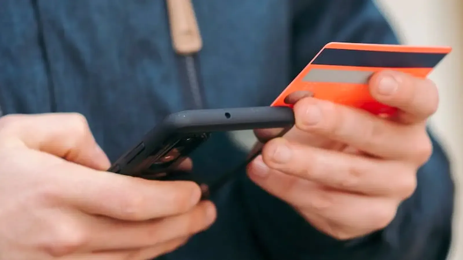 Person holding their phone and their credit card