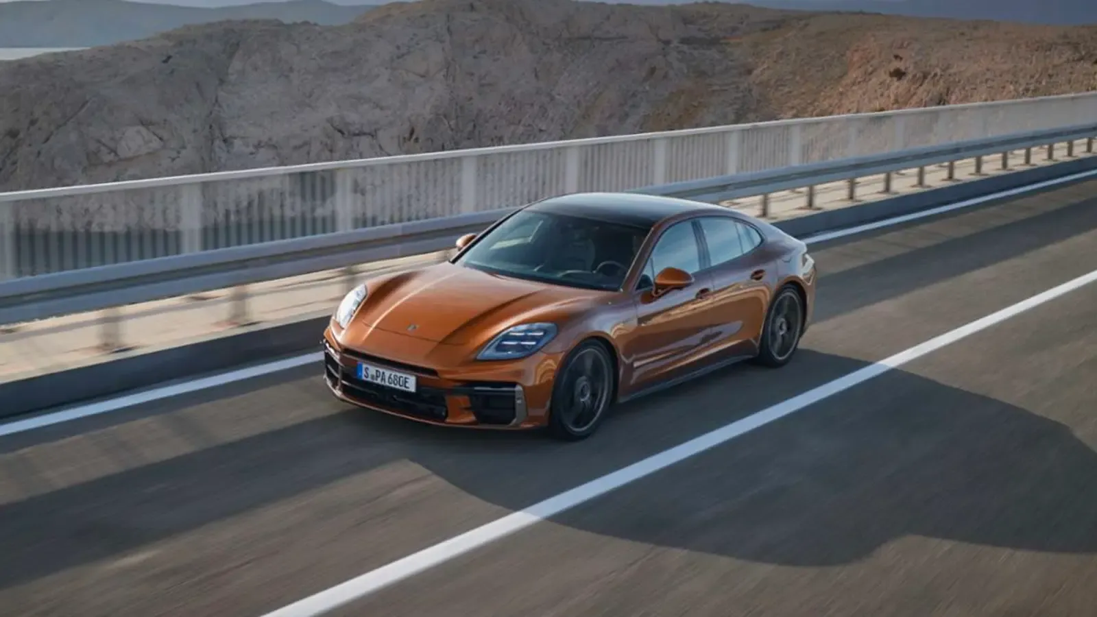 Orange Porsche Panamera Hybrid driving on the road