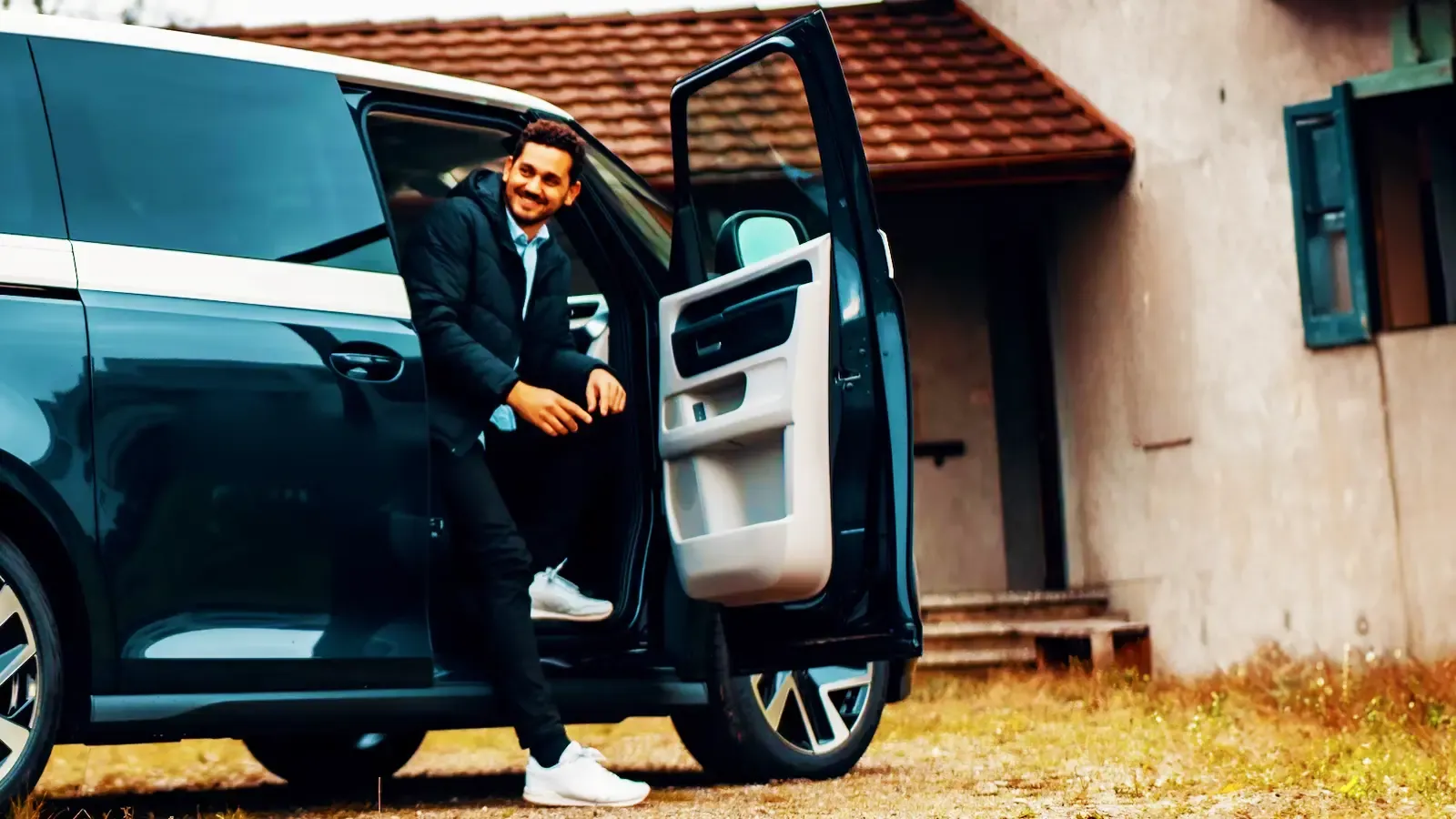 Man sitting with car door open of an electric car