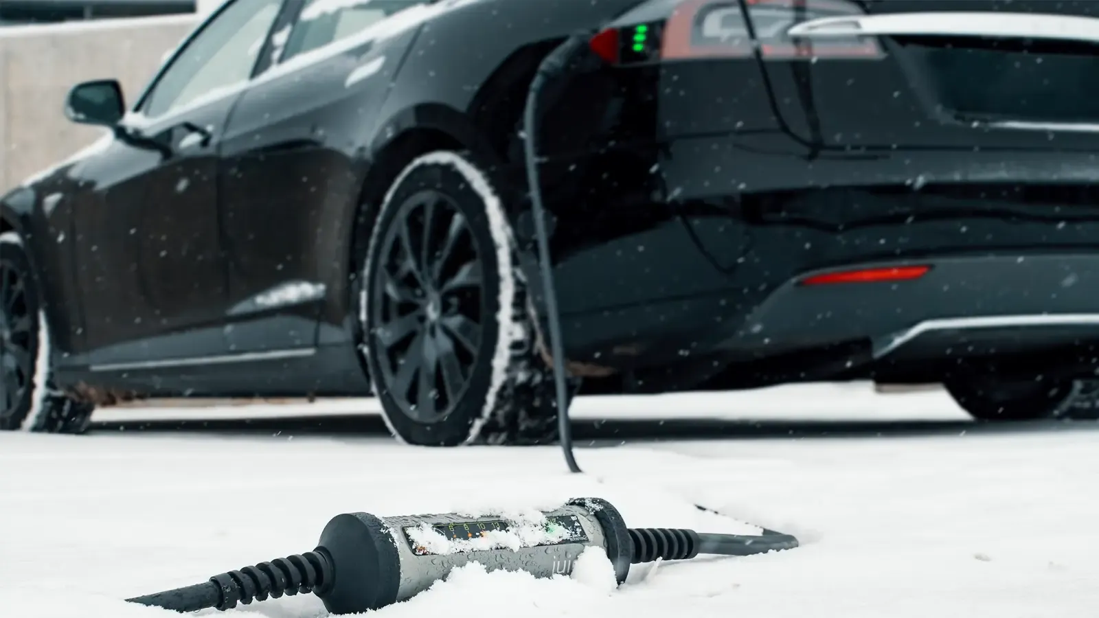 Electric car charger lying in the snow and charging a car
