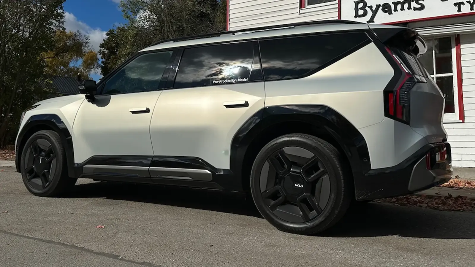 Kia EV9 side exterior view parked by a shop 