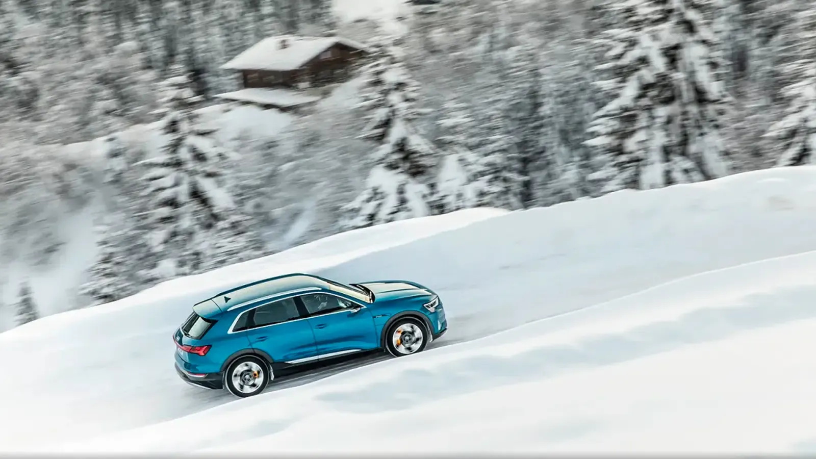 Audi E-tron driving in s very snowy road 