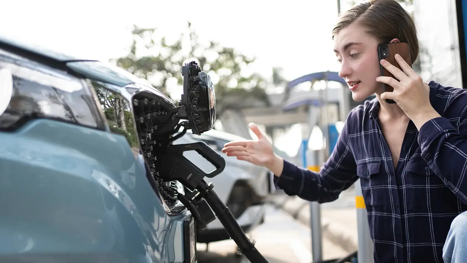 Woman on the phone sitting next to her EV charging 