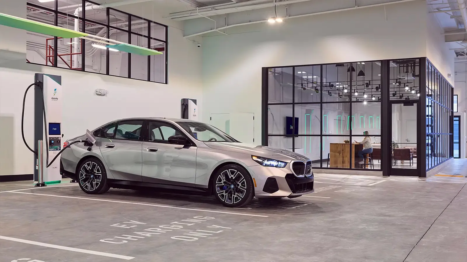 Electrify America’s new flagship charging station view of a car charging by a lounging room 