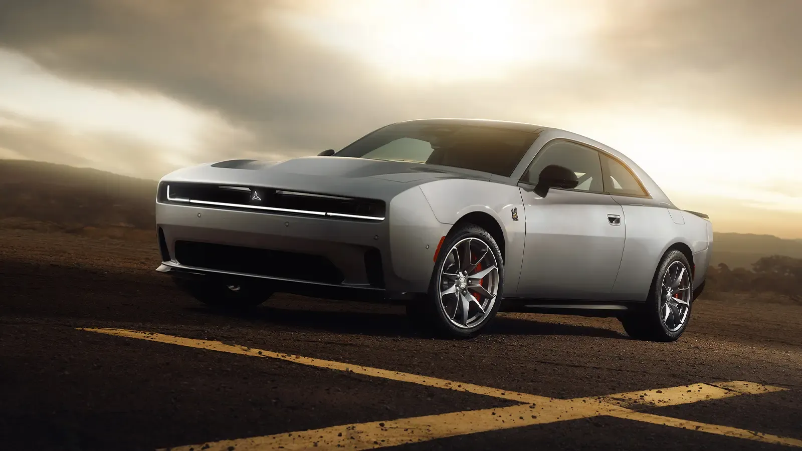 Electric Dodge Charger parked on asphalt with a dramatic stormy sky in the background