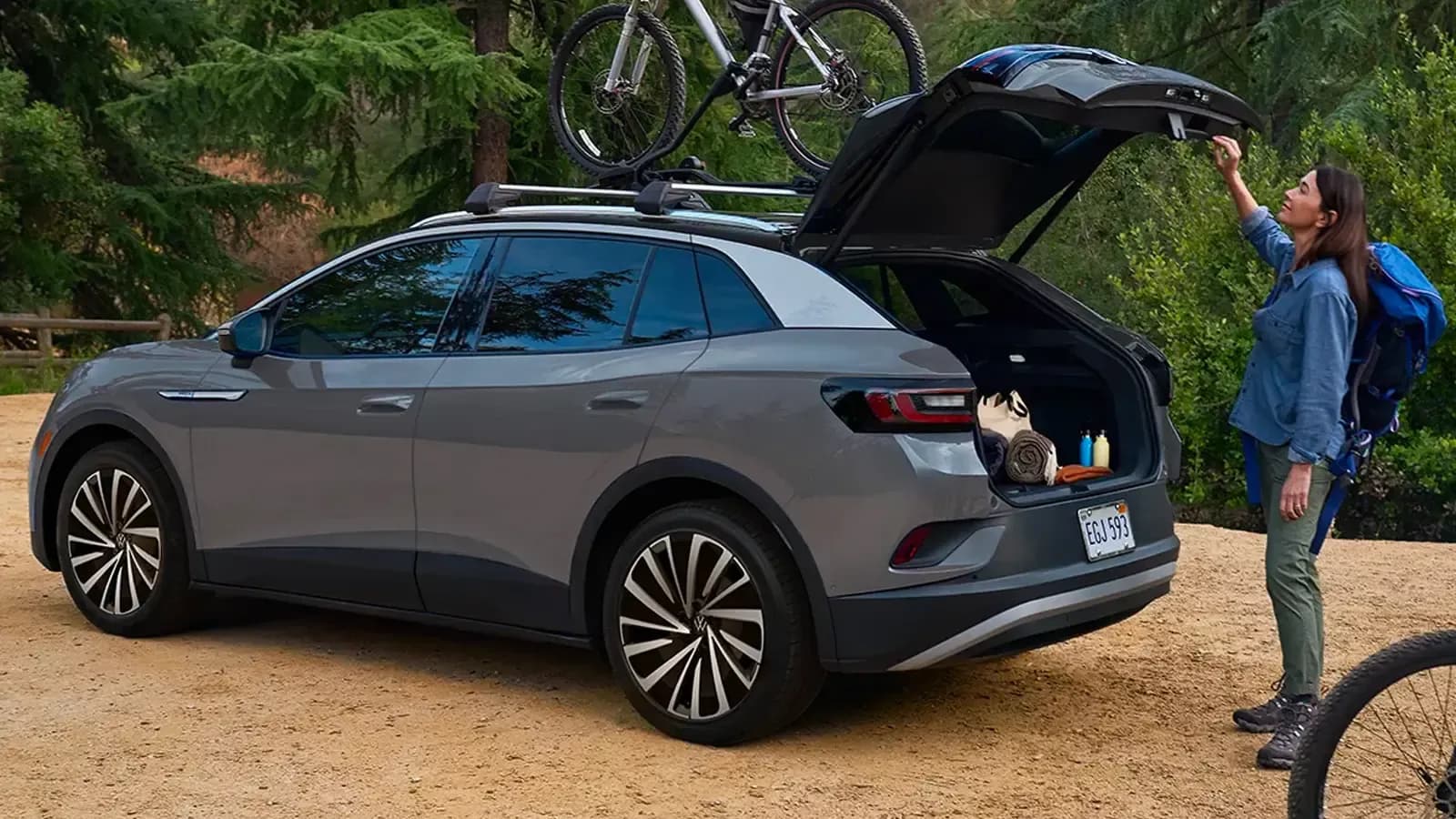 Woman opening the trunk of her Volkswagen ID4 by a park 