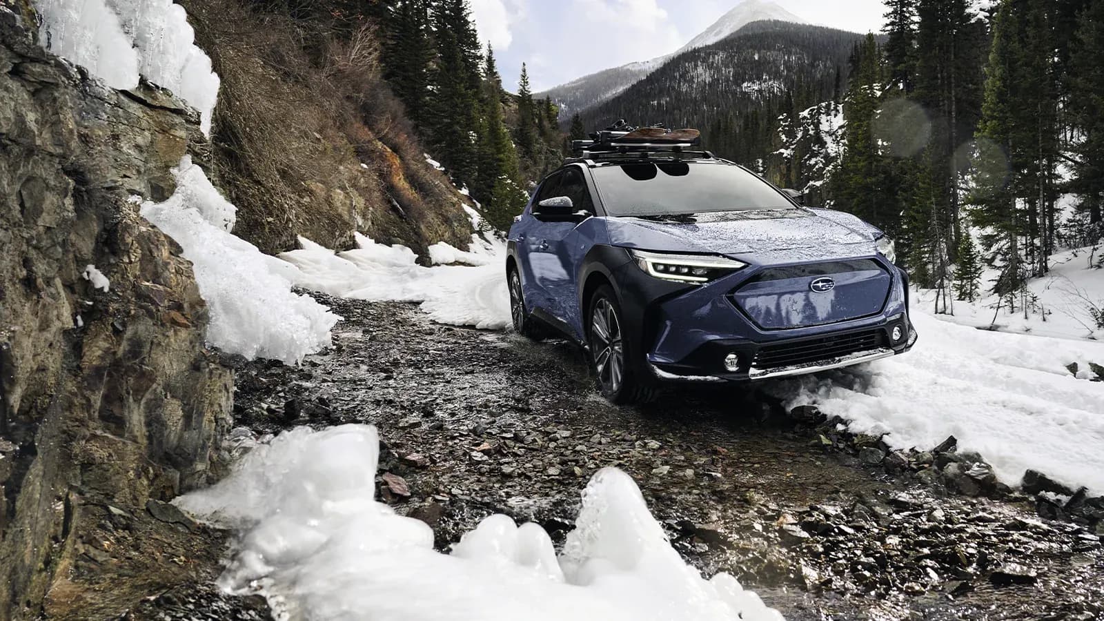 EV Subaru Solterra driving up snowy mountain road