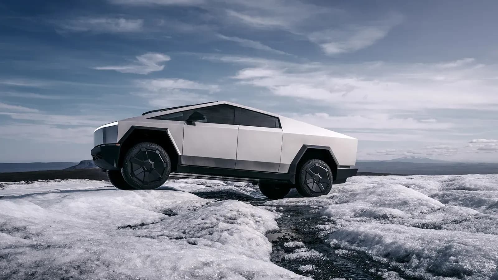 a white Tesla Cybertruck driving through ice