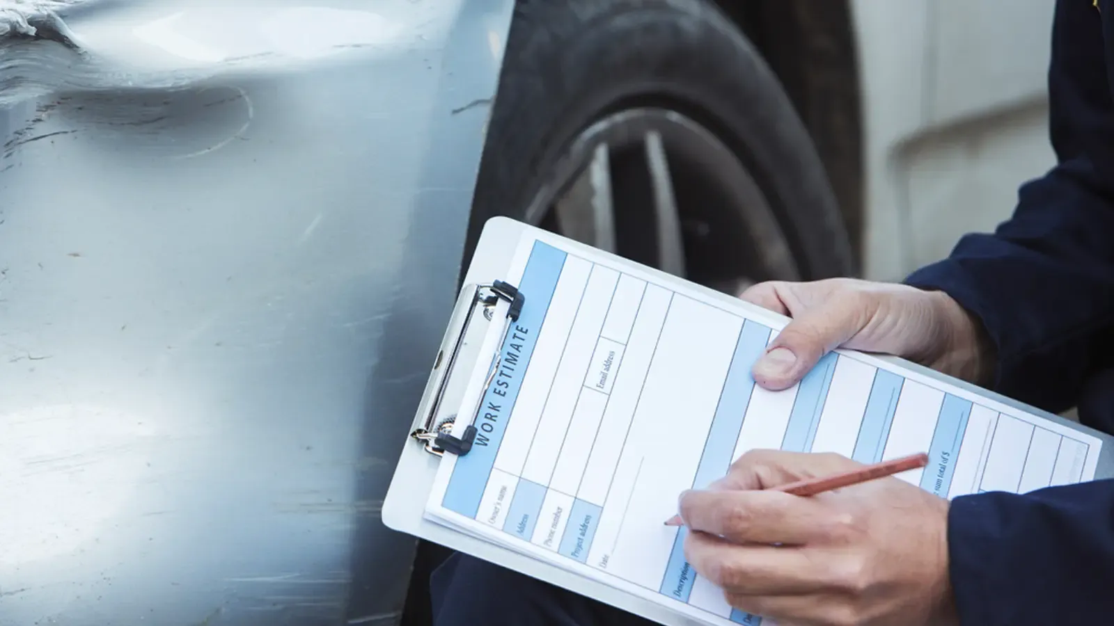Person filling out an inspection form after car damage 