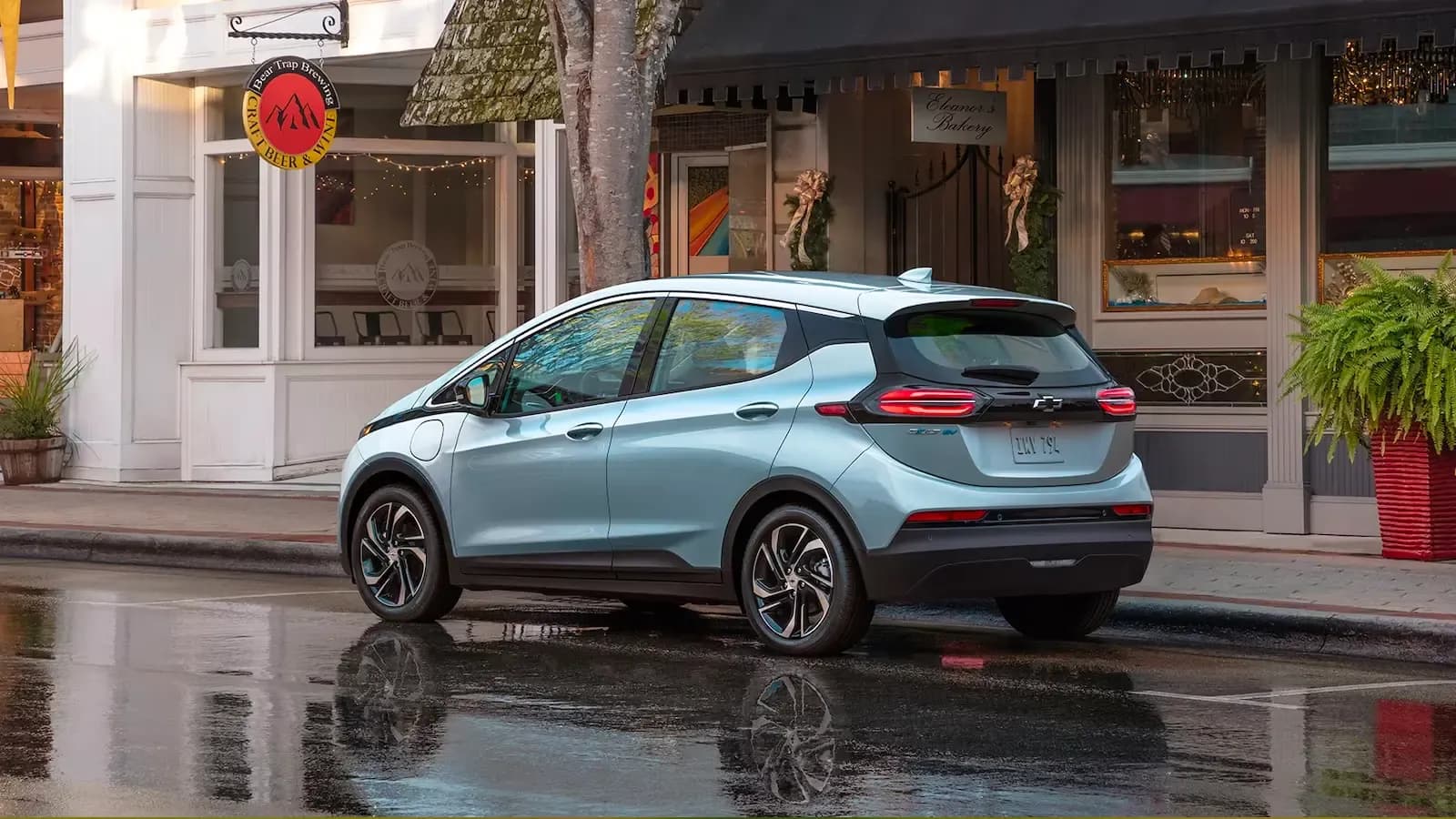 Chevrolet Bolt driving on a rainy road, back view of the exterior 