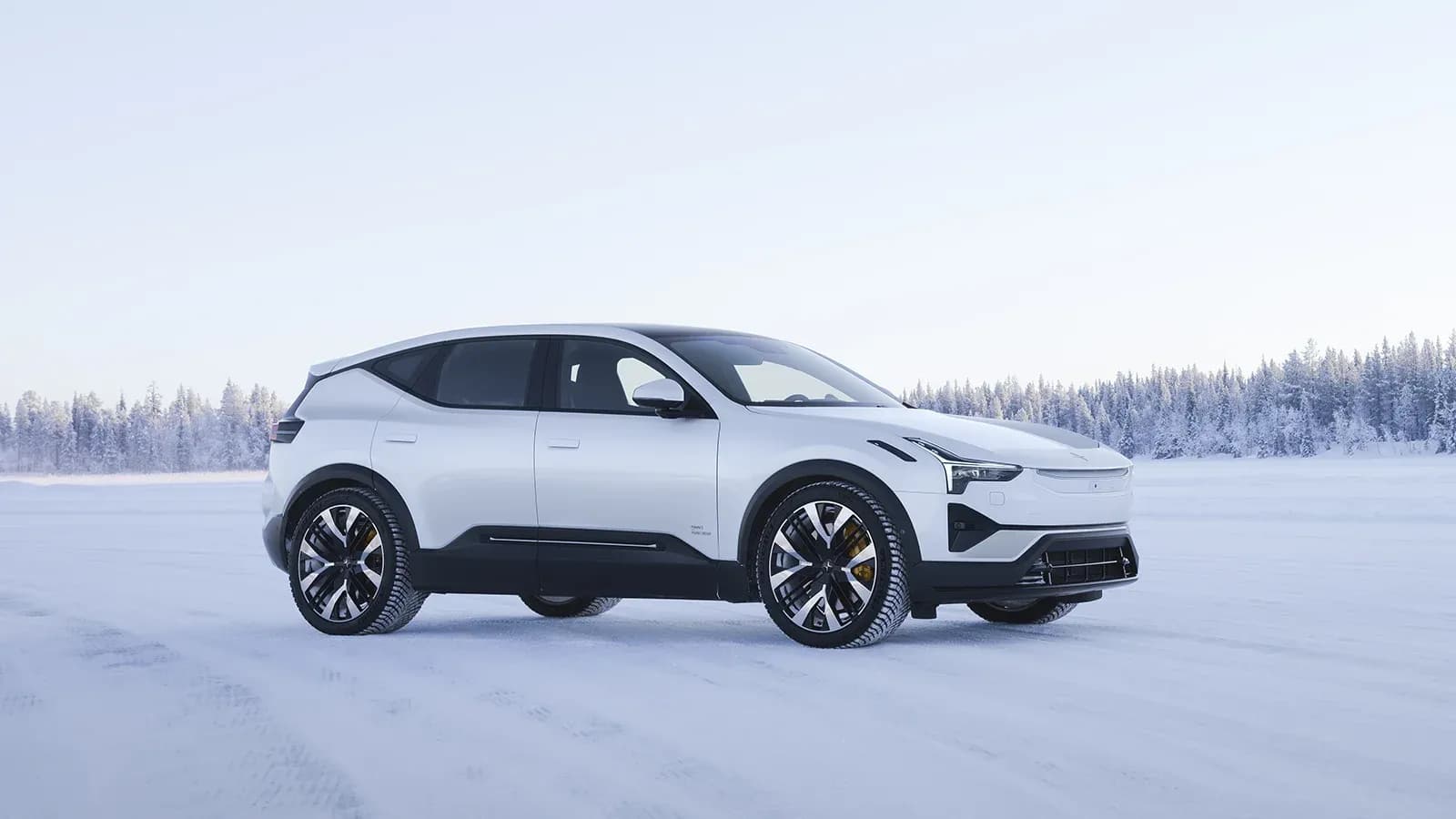 White Polestar 3 in front of a snowy forest