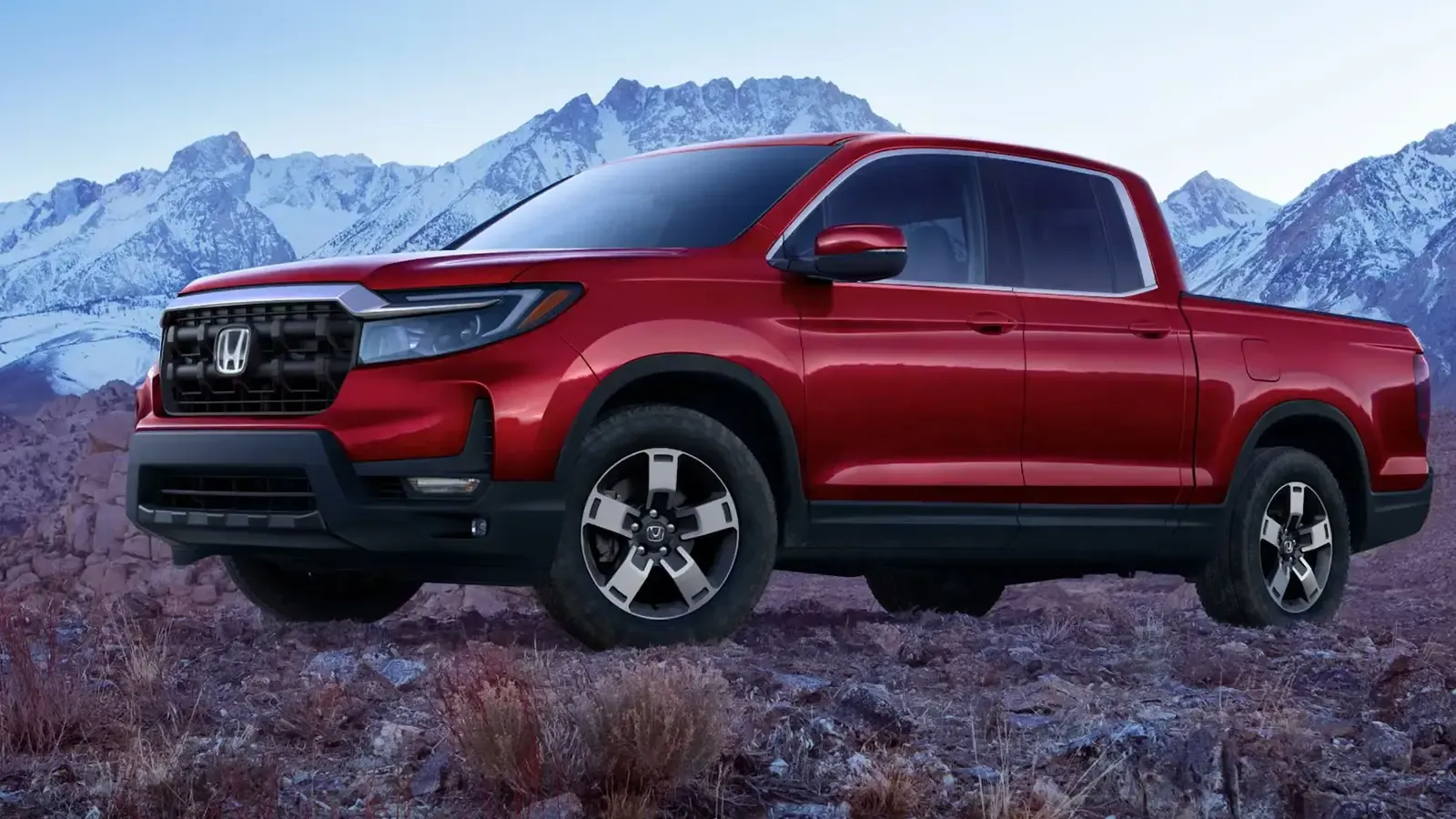 A red 2025 Honda Ridgeline parked with a mountain backdrop