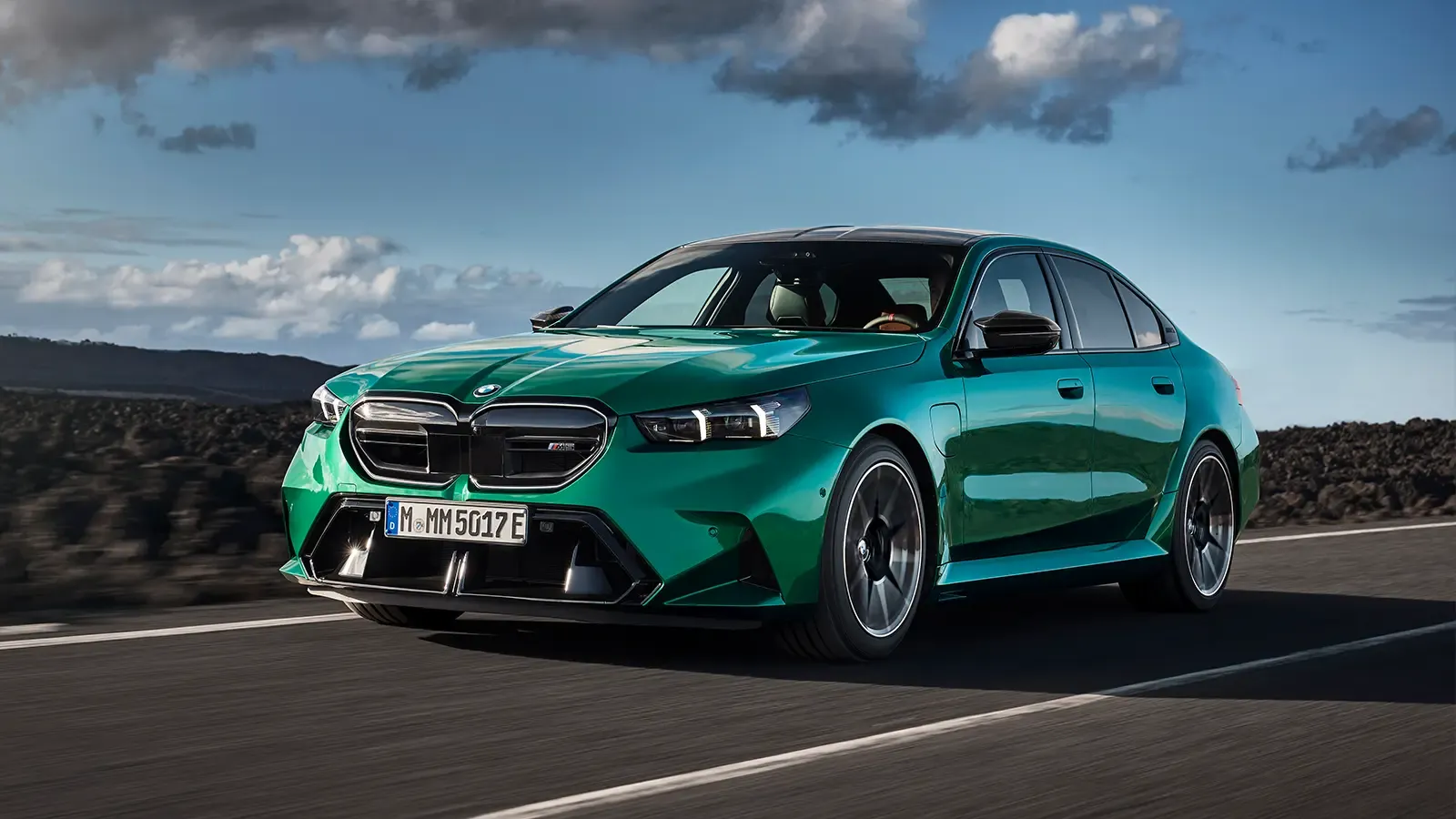 A green 2025 BMW M5 driving