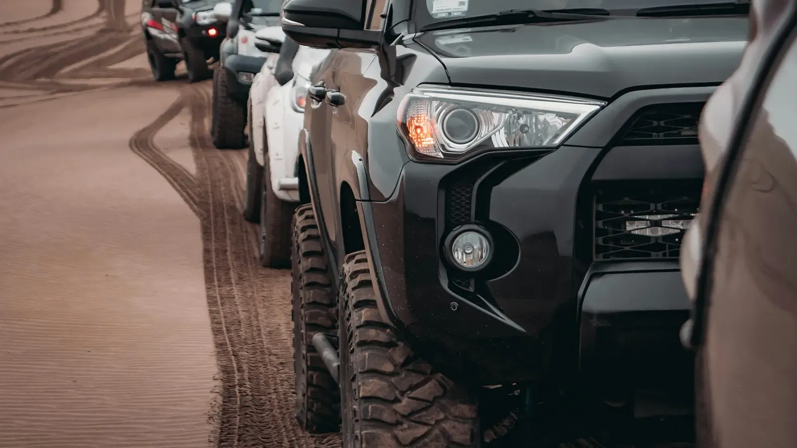 A caravan of Toyota SUV's in the desert.