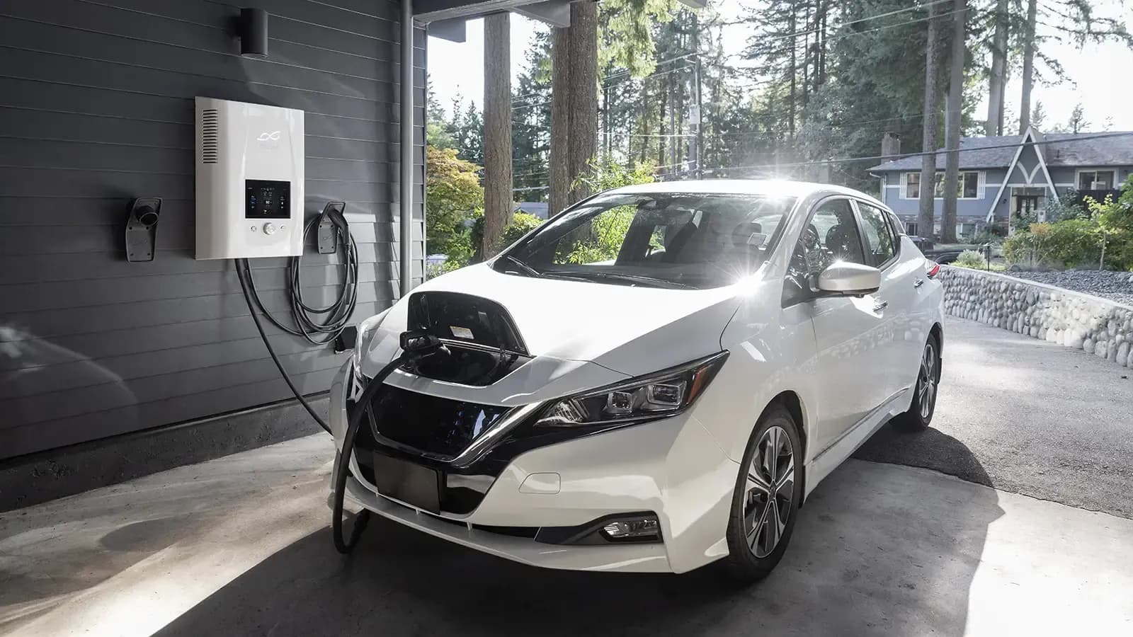 A white Nissan Leaf charging at house in garage