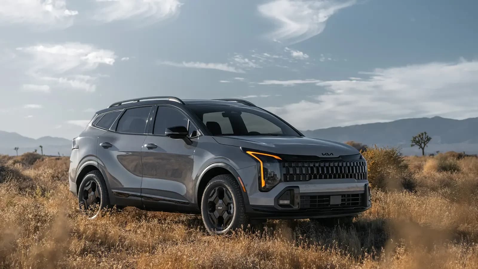 A gray 2026 Kia Sportage three quarter front view in the desert