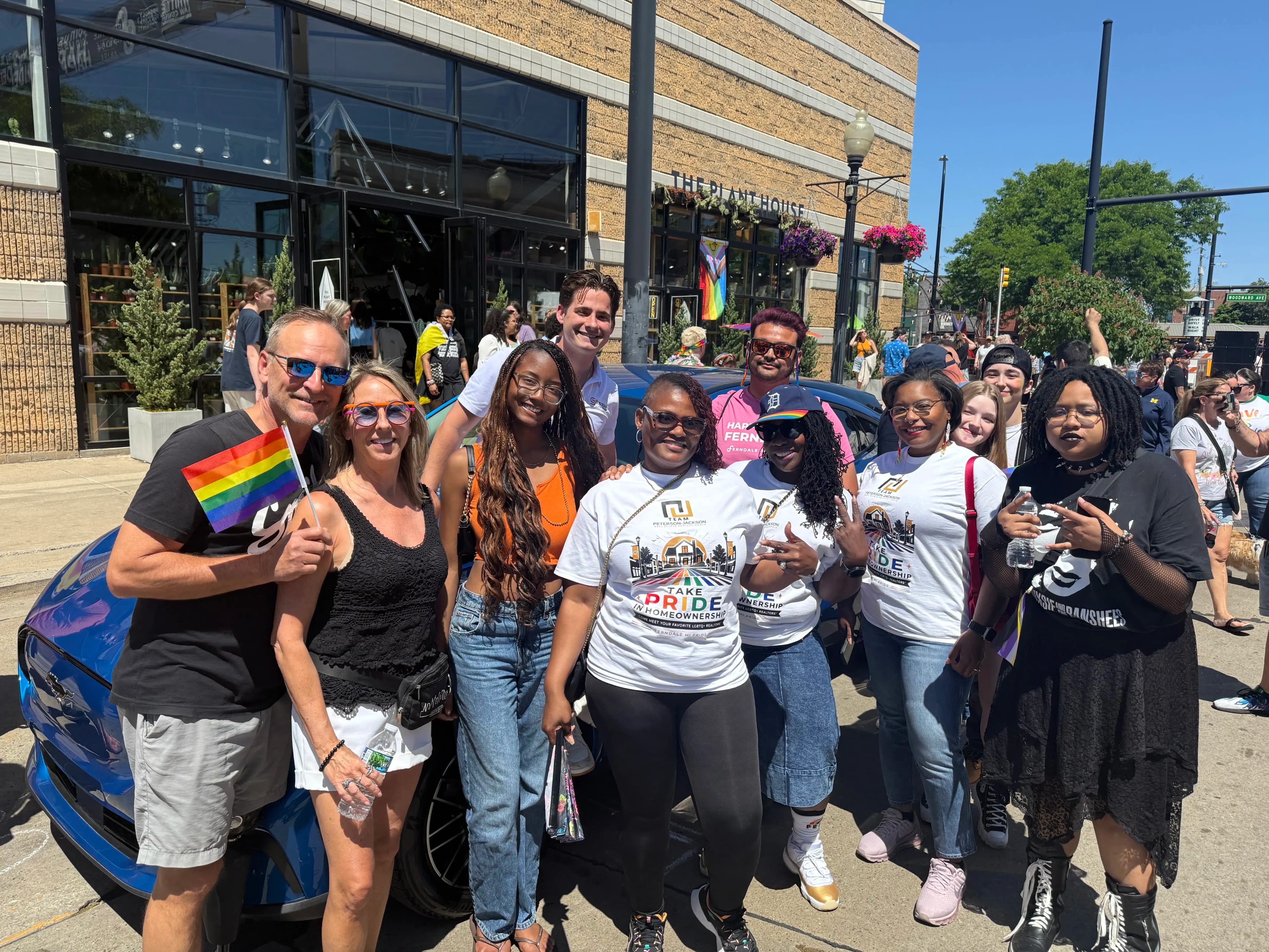 Group of people posing in front of a blue Mustang Mach-E at Ferndale Pride.
